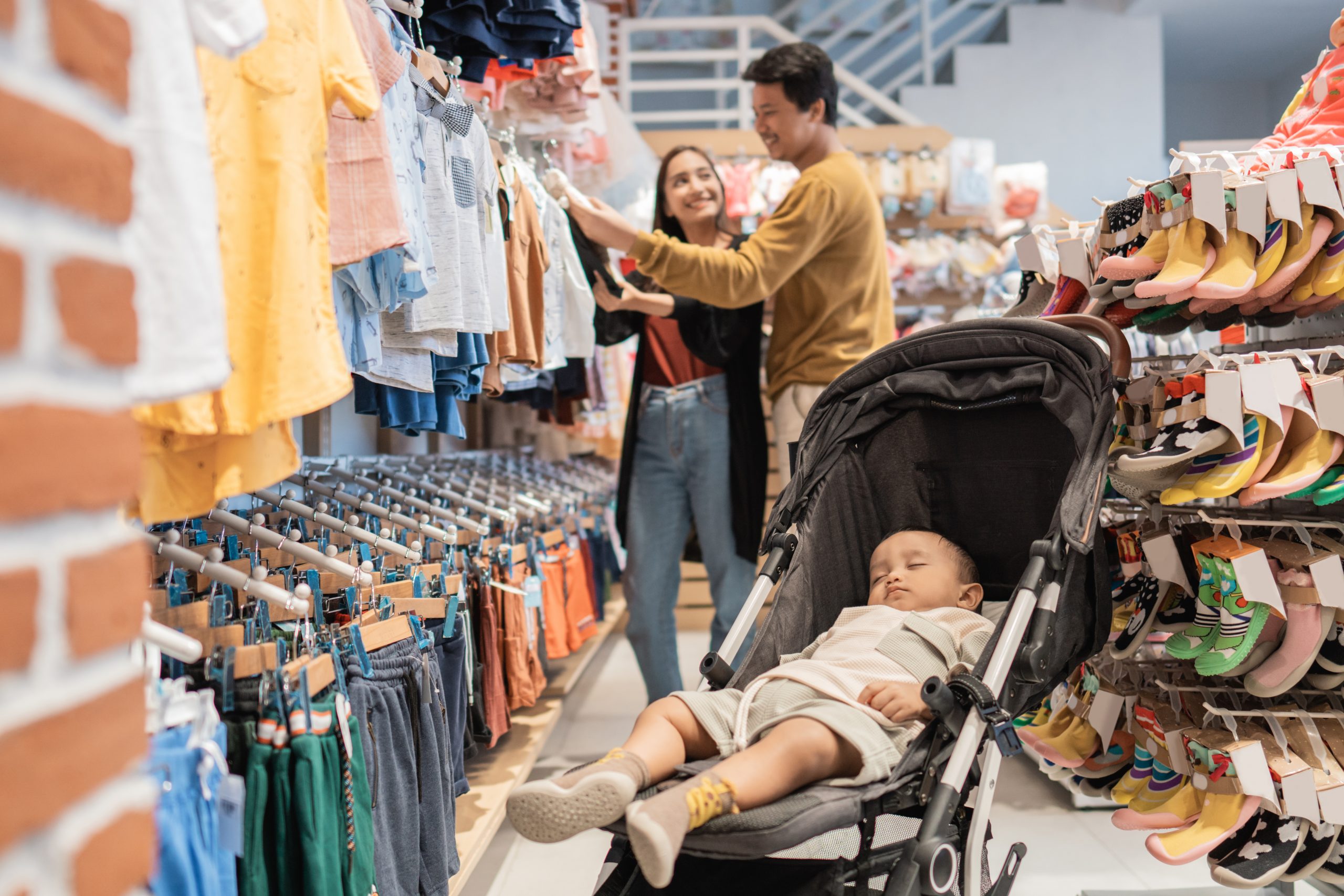 happy beautiful asian mother with her toddler boy shopping in the baby shop